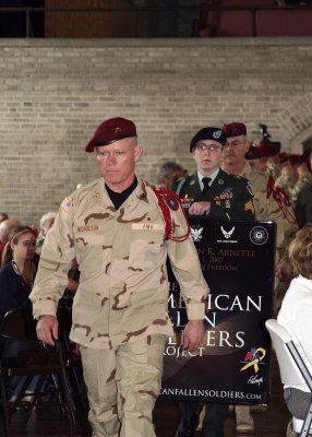 Brigadier General Larry Nicholson accompanies a new Fallen Soldiers portrait to the stage