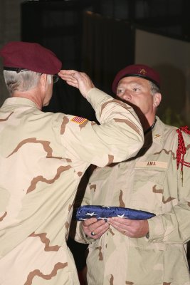 During the White Table ceremony, B. Nicholson salutes Mitchell before accepting the flag