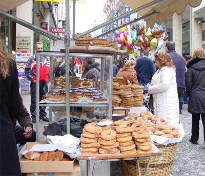Street vendor selling donuts, bread and sesame pretzel-look-a-like