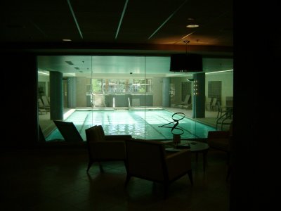 A pool view from inside the main Spa area, with the Jacuzzi at the far-end of the pool, the lady's locker room to the right and the men's locker room to the left.