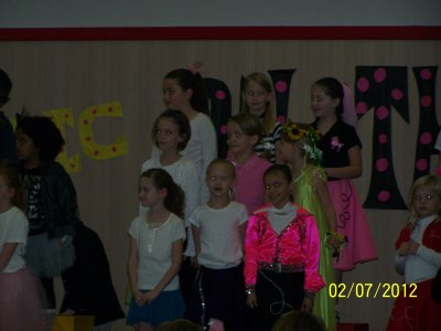 Our granddaughter's second grade class put on a musical presentation.  My camera batteries died after taking just one photo {:-( , but I also have their performance on camcorder.  She is in the front row, left end in this picture (wearing a white top).