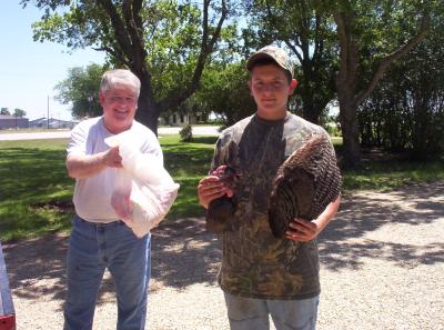 Alex holding 1 wing and the head while his Dad is holding the turkey breat meat in the plastic bag.