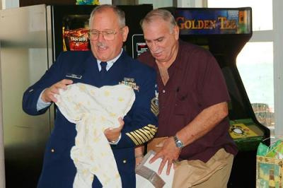 BMCM Paul DeBold opening gifts at his retirement ceremony with DC1 Dave Shiffman assisting