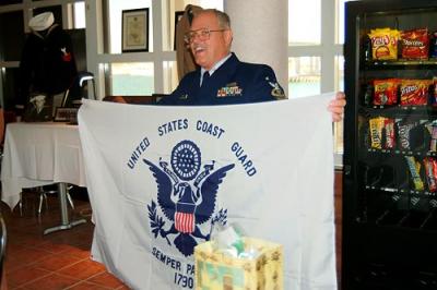 BMCM Paul DeBold displaying his new bedroom wall decoration at his retirement ceremony