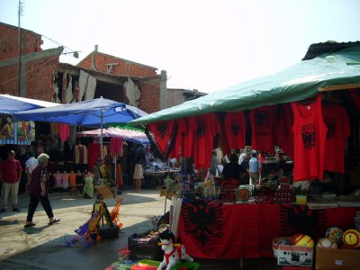 Albanian nationalism (double headed eagle) and destroyed houses in the bazaar in Pec