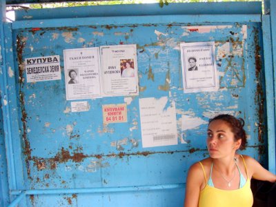 jana at a burgas bus stop, obits posted on wall