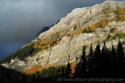Stormy clouds rolling over autumn-coloured mountains