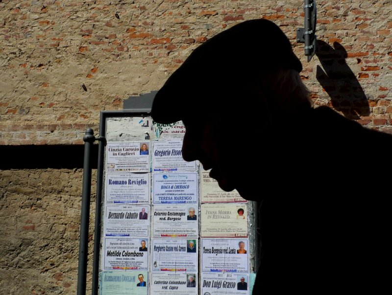 The last Contrast - A old man walk in front obituary notices of his fellow citizens