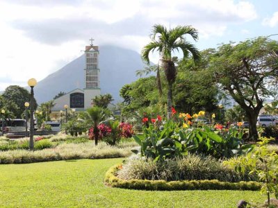 The central park plaza in La Fortuna & La Fortuna Iglesia de Cristo (Church of Christ). Arenal Volcano is in the background.