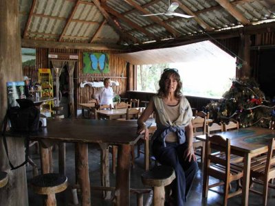 Judy waiting for lunch at the restaurant beside the demonstration of how to extract juice from sugar cane.