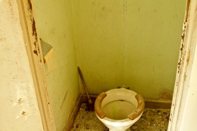 Toalett i omklädningsrummets hygiendel med orginalpapper kvar i hållaren.