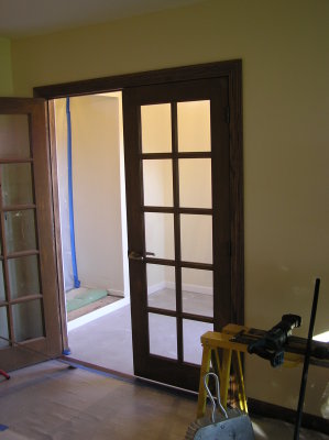 The new french doors,  looking out into the foyer.  There is no flooring in the foyer or halls yet.
