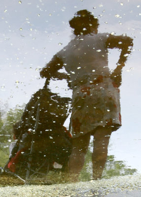 Woman & Baby Stroller Reflected in a Puddle of Water