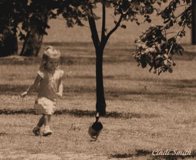 LITTLE GIRL CHASING THE DUCK
