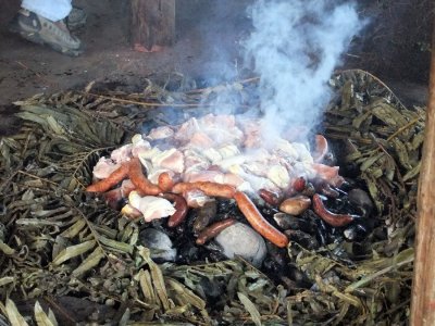 A curanto meal consisting of shellfish, meats, potatoes, and vegetables, cooked over hot rocks in a hole in the ground