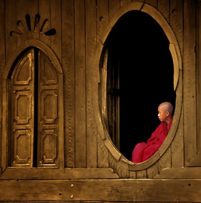 Novice seated in an oval teak wood window 