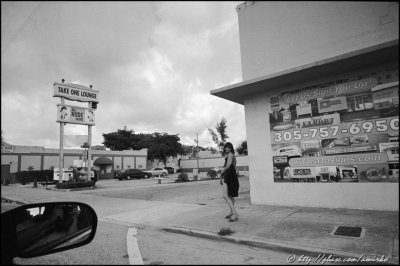 Woman standing by the strip club on NW 79th street