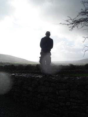 A cold wet and wickedly ugly American, standing on a wall.