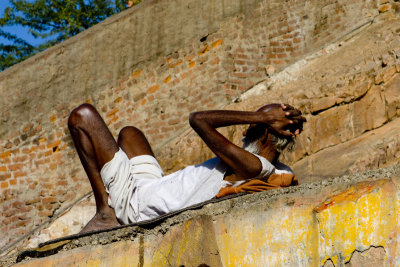 Thin guy sleeping on an inclined wall at the monkey temple