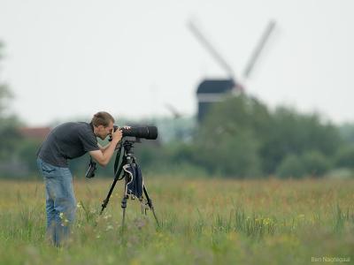 Rob in a field with a dutch windmill in the background