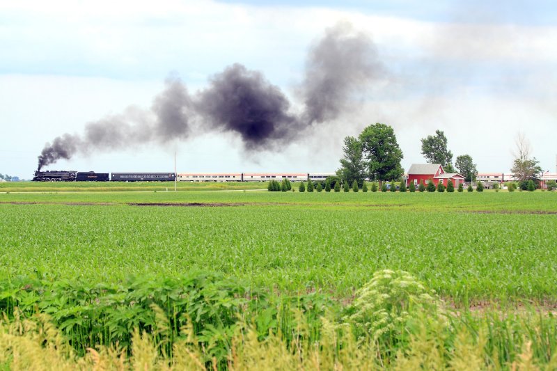 Northbound Nickel Plate steam passes a well kept homestead along the C&O mainline