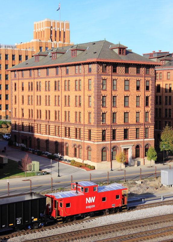 A freshly painted N&W cabb trails a coal train through downtown Roanoke, and past the N&W general office building 