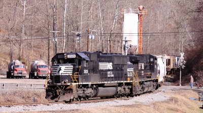 A local is spotting cars on the Tug Fork branch, while a golfer waits to cross the tracks to the next hole. 