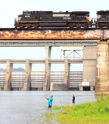 3 fisherman go about thier work as NS 282 passes above 