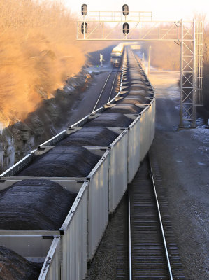 Indiana coal heads for a Kentucky power plant, as a train of fresh Toyotas waits