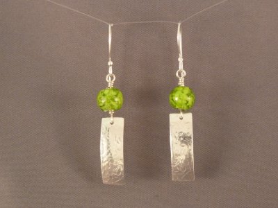 Small green lamp work beads above textured sterling dangles.