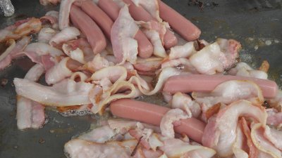 Cooking  hotdogs with bacon