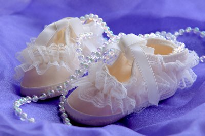White Christening Boots on Pale Blue Background