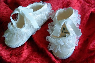 White Christening Boots on Red Background