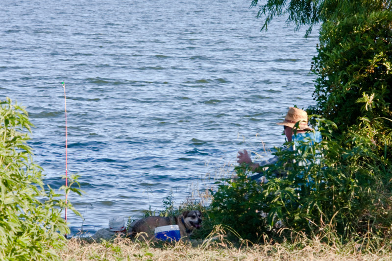 Just a man and his dog... waiting for the fish to bite. 