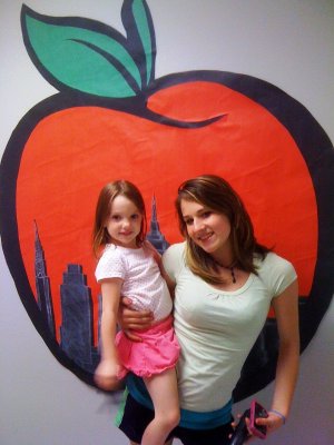 Anna in front of the Big Apple wall display