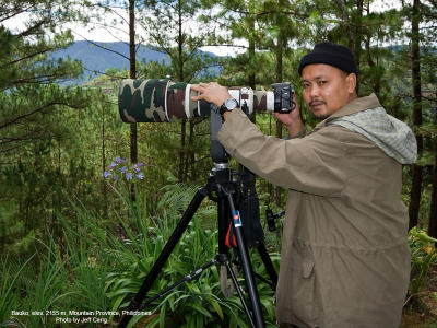 HIGHLAND BIRDING. I'm waiting for montane birds at elevation 2155 meters (Bauko, Mountain Province) when my brother Jeff snapped this pic. 
My light birding combo is the 20D + 500 f4 L IS + Canon 1.4x TC, mounted on a Manfrotto 3421 gimbal head and 475B tripod.
The black bonnet insulates my top spot against the cold mountain temperature, as my hair had divorced me about a decade ago....;-)

[350D + Sigma 10-20, hand held]