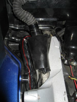Harness is looped under rear subframe and then over to trunk hole