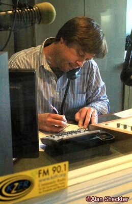 Through-the-glass view of a KZFR volunteer taking a pledge