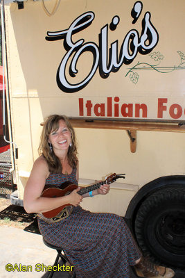 Musician CJ Alegre strumming by the Elio's Italian food truck