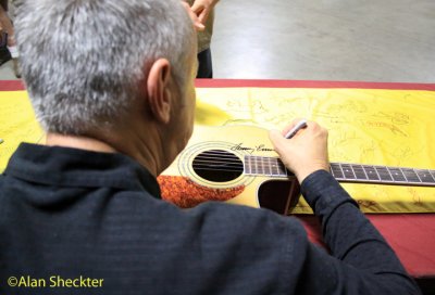 Tommy Emmanuel signs a guitar