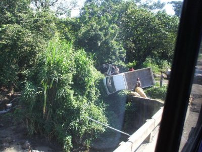 Puerto Quetzal, Guatamala-truck just gone over side, cop opening door to get driver out. river was below