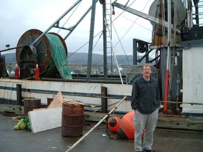 Don next to a fishing boat; it was strapped to the dock and up on a rack because all the water was out (tide!)