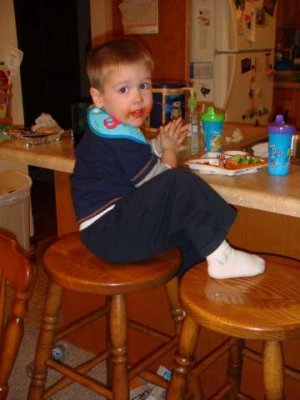 joe enjoys being a big boy and sitting on grandma's stool for his meals