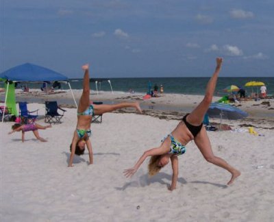 Hand stands in the sand. Ft - Bk daughter Amy,friend Kira and grand daughter Taylor. June 06