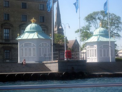 The Royal family waits to board their yacht in the gazebo on the left, others of their party wait in the right gazebo.