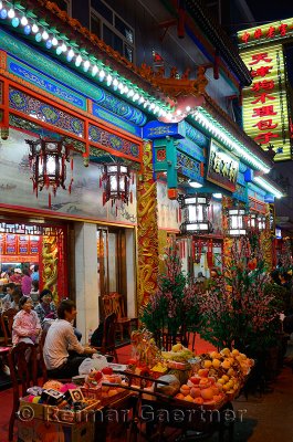 Chinese family sitting outside a restaurant by street vendors at night in Beijing