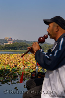 Man playing a Hulusi or Curcubit flute at Hall of Recognition of Talent Island in Kunming Lake Summer Palace Beijing