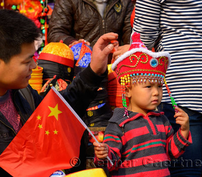 Father and son at a hat shop in Forbidden City Beijing with Chinese flag