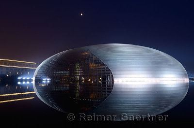National Centre for the Performing Arts egg at night with moon and Great Hall of the People in Beijing