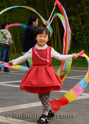 Young Chinese girl waving streamers at Zizhuyuan Purple Bamboo Park Beijing